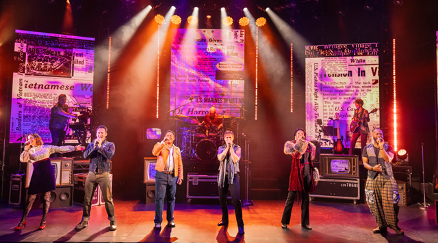A group of people on a stage singing
Description automatically generated