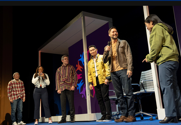 A group of people on a stage
Description automatically generated